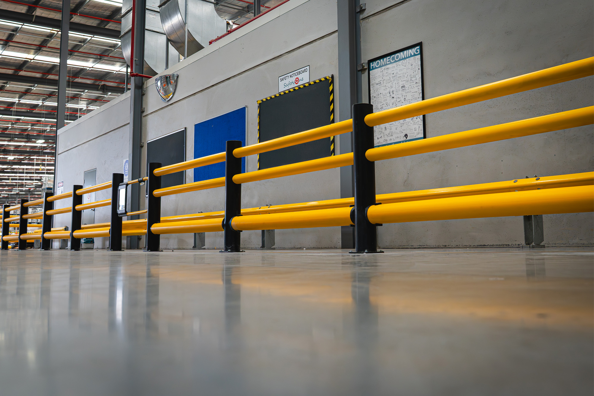 倉庫内の歩行者通路を黄色と黒の安全柵で分離した施工例